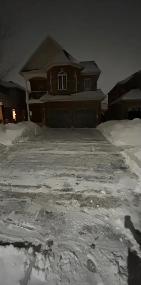 Same driveway cleared at night during the storm