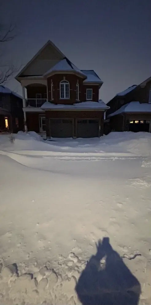 Driveway under heavy snow at night before clearing
