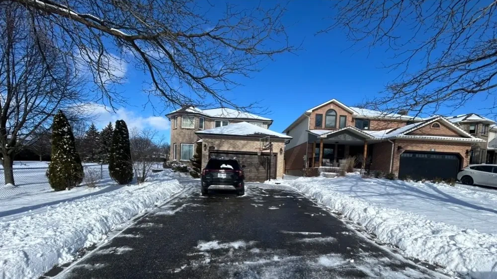 Driveway cleared down to pavement under a blue sky